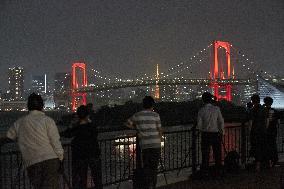 Rainbow Bridge lit up in red